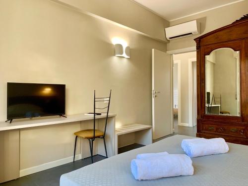 a bedroom with a bed and a desk and a tv at Maison A in La Spezia