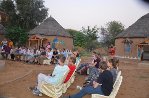 a group of people sitting in chairs in front of a crowd at Desert Nights in Mandāwa