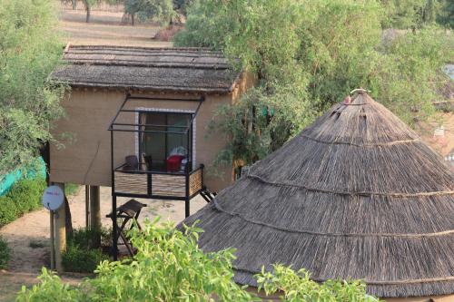 a small hut with a thatch roof and a window at Desert Nights in Mandāwa