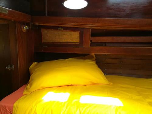 a yellow bed with a wooden headboard and lights on it at Margarethe in Marina di Pisa