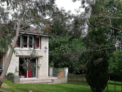 une maison en briques blanches avec des fenêtres rouges et une clôture dans l'établissement La mare au Loup, à Vitré