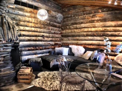 a living room with a couch and a wooden wall at Ruka Chalet Charmant Oliver in Ruka