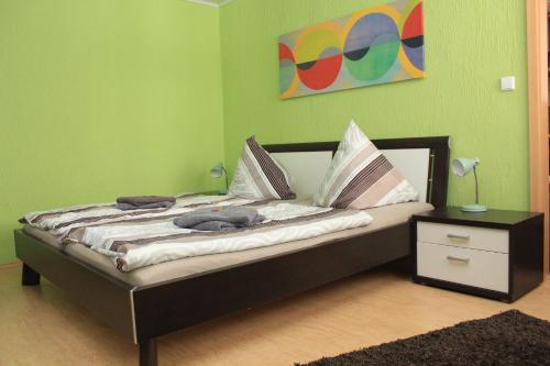 Cama en habitación con pared verde en Ferienwohnung-Kiefer, en Hillscheid