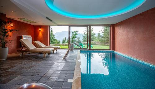 プラマンタにあるAnavasi Mountain Resortの大きな窓付きの客室内のスイミングプールを利用できます。