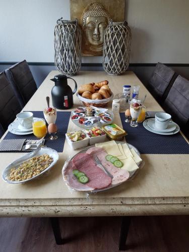 a table with breakfast foods on it with a statue at B&B Dersum Dream in Dersum