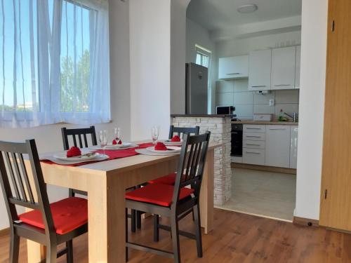 - une cuisine et une salle à manger avec une table et des chaises dans l'établissement Apartman Igy, à Vinkuran