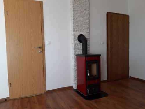 a room with a wood stove next to a door at Apartman Igy in Vinkuran