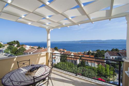 balcón con mesa y vistas al agua en Villa Marina Bol, en Bol