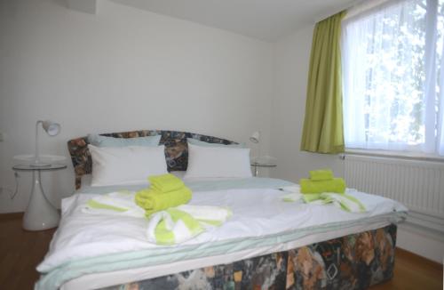 een slaapkamer met een bed met groene handdoeken erop bij Schöne Höhe in Pirna