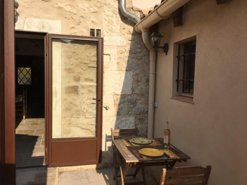 - une table et des chaises sur une terrasse à côté d'une porte dans l'établissement La maussanaise, à Maussane-les-Alpilles