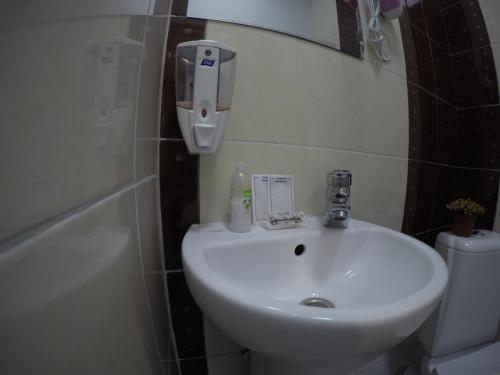 Un baño con lavabo, inodoro y espejo. en sweet home 2, en Ivano-Frankivsk