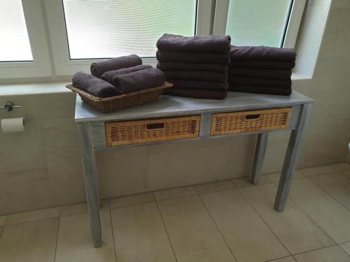een tafel met handdoeken en manden in de badkamer bij B&B Dersum Dream in Dersum