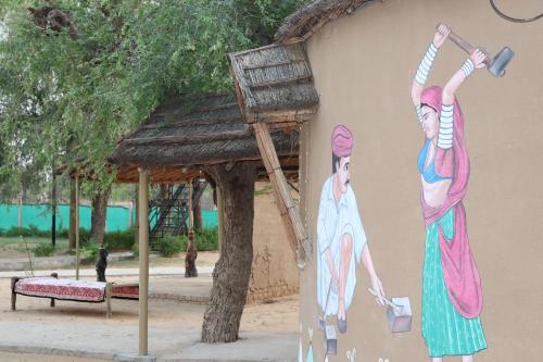 a painting of two women on the side of a building at Desert Nights in Mandāwa
