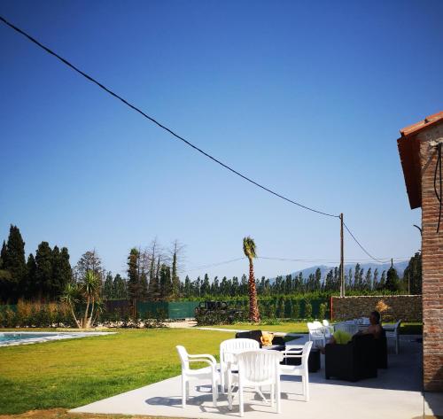 a group of white chairs and tables in a yard at Mas Puig in Saint-Genis-des-Fontaines