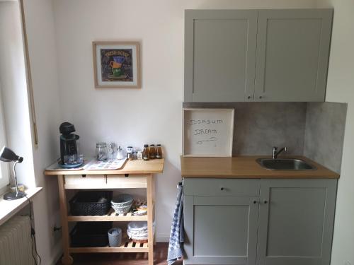 a kitchen with white cabinets and a sink at B&B Dersum Dream in Dersum