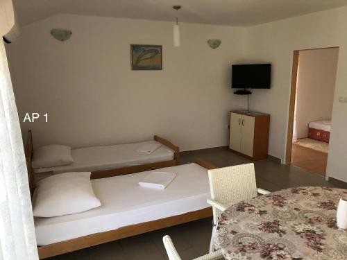 Habitación pequeña con cama y mesa en Apartments Zora, en Rogoznica