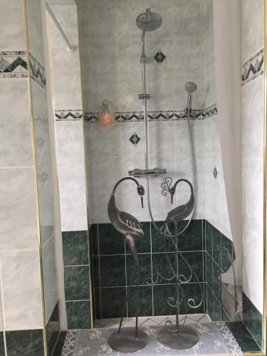 dwóch flamingów siedzących pod prysznicem w łazience w obiekcie Chambres d'hôtes Chez Coco w mieście Saint-Georges-de-Reneins