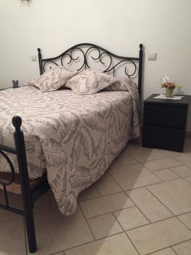- un lit avec un cadre noir et une couverture blanche dans l'établissement Chambres d'hôtes Chez Coco, à Saint-Georges-de-Reneins