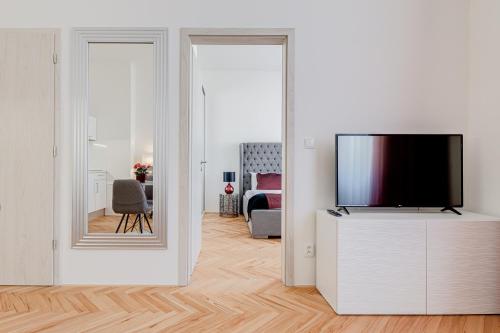 a living room with a tv and a mirror at Gold Art Apartments in Prague