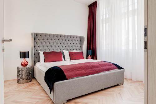 a bedroom with a large bed with red pillows at Gold Art Apartments in Prague