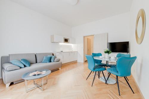 a living room with a couch and a table and chairs at Gold Art Apartments in Prague