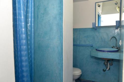 niebieska łazienka z umywalką i toaletą w obiekcie Dammusi Eleonora w mieście Kamma