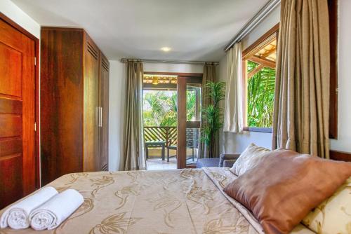 a bedroom with a bed with two towels on it at Unidades Vilas Triplex no Pipa Beleza in Pipa