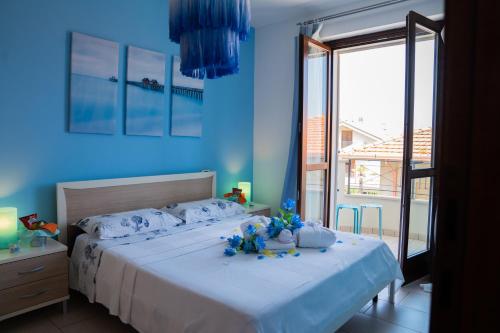 アルバ・アドリアティカにあるAppartamenti Abruzzo Rabelの青い壁のベッドルーム1室(大型ベッド1台付)