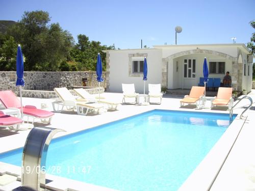 a swimming pool with lounge chairs and a house at Vila Rogač in Tivat