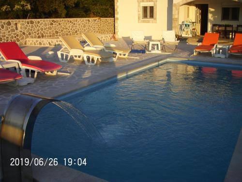 a swimming pool with lounge chairs and a swimming pool at Vila Rogač in Tivat