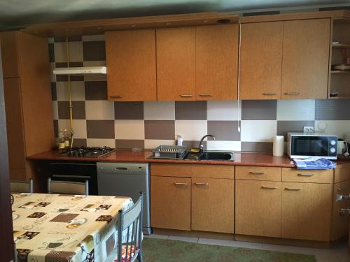 a kitchen with wooden cabinets and a sink and a microwave at La Teo in Măru