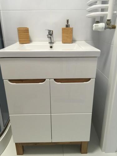 a bathroom with a white sink and white cabinets at Bolero in Dziwnówek