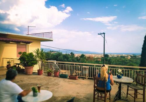 a group of people sitting at tables on a balcony at Anita's hosting in Kalamata