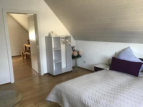 a bedroom with a white bed and a room with a table at Ferienwohnung Elina in Maxhütte-Haidhof