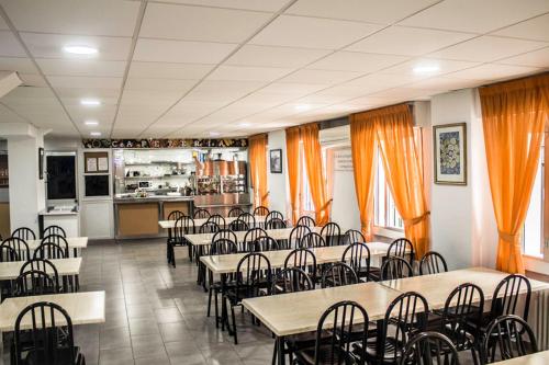 a dining room with tables and chairs and a kitchen at Residencia Gómez Pardo in Madrid