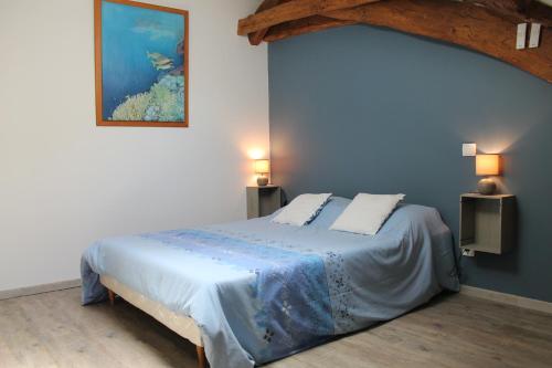 a bedroom with a bed with a painting on the wall at GITE clodeguy in Saint-Sylvestre-sur-Lot