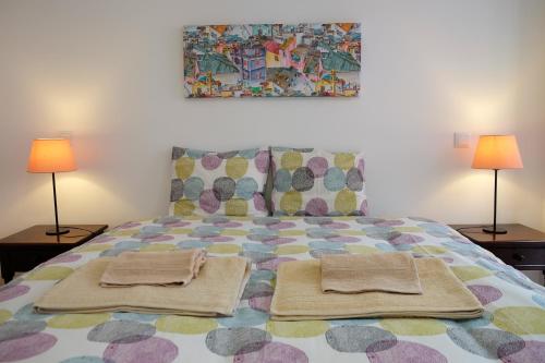 a bedroom with a bed with two lamps and two towels at RomanticHome at Alfama's Heart in Lisbon