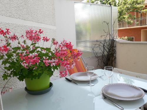 a table with a vase with pink flowers on it at :) Grand studio lumineux à Toulouse et parking in Toulouse