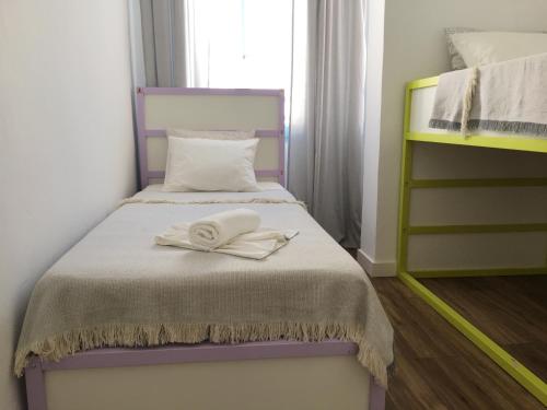 ein Schlafzimmer mit einem Bett mit zwei weißen Handtüchern darauf in der Unterkunft Ladrillo, apartment by the sea, Santa Pola in Santa Pola