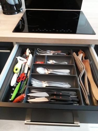 a drawer in a cabinet filled with utensils at :) Grand studio lumineux à Toulouse et parking in Toulouse