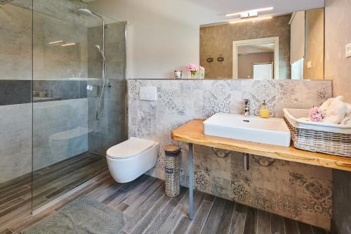 a bathroom with a sink and a toilet and a shower at Villa Celeste in Umag