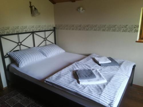 Una cama con dos toallas encima. en Istria Divina en Marezige