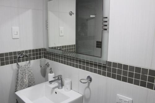 y baño con lavabo y espejo. en Cozy Apartment in El Laguito, en Cartagena de Indias