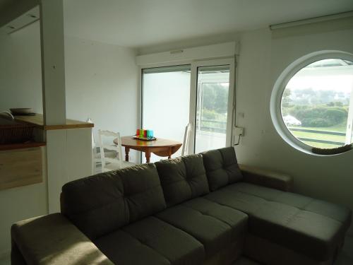 - un salon avec un canapé et une fenêtre ovale dans l'établissement studio Kelenn à Carantec, à Carantec