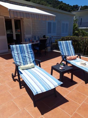two blue chairs and a table on a patio at House Daniva in Okuklje