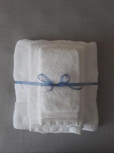 a white towel with a blue ribbon on it at Muragie del Castello B&B in Trani