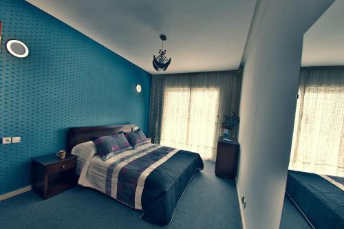 ein Schlafzimmer mit einem Bett und einer blauen Wand in der Unterkunft Amazing New Central Apartment, Modern, very Clean and very Comfortable in Rabat