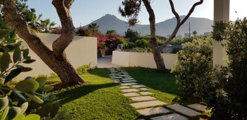 a garden with trees and a stone path at Casa Mirella in Favignana