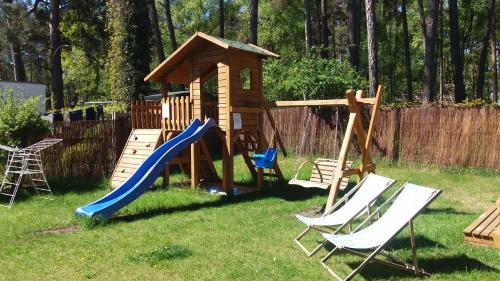 a playground with two chairs and a slide at apartamenty Orla in Międzyzdroje