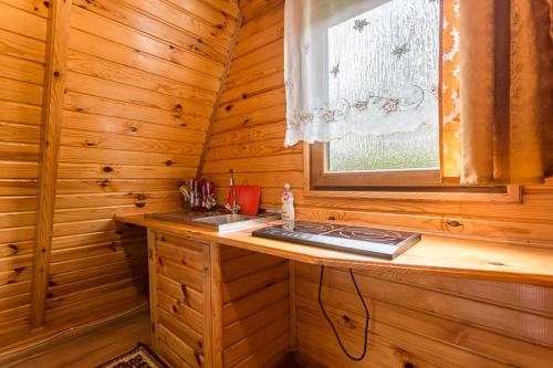 uma cabina de madeira com um lavatório e uma janela em DOMKI u JÓZKA em Polańczyk